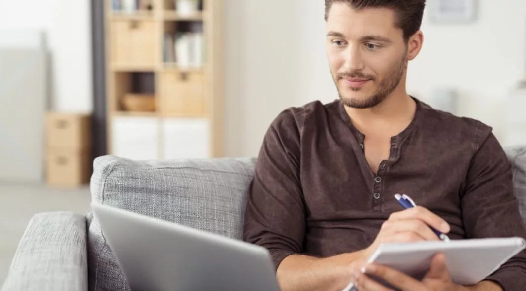 homme qui prend des notes sur des biens